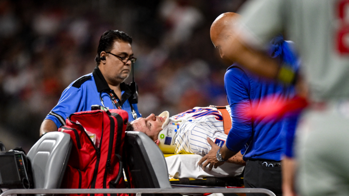 Jared Young dari Mets dibawa keluar lapangan setelah bertabrakan dengan Nolan McLean